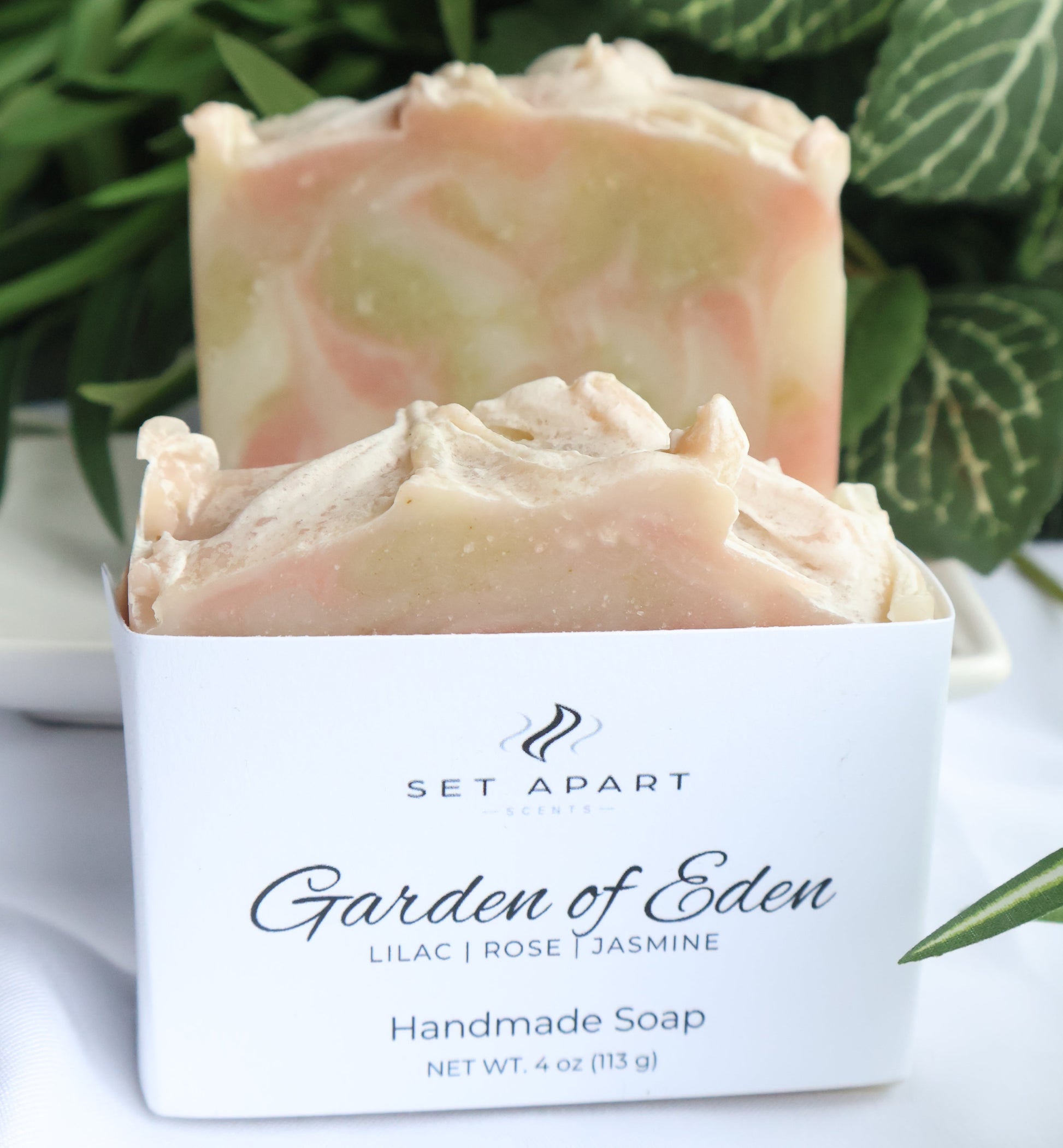 Handmade soap with a 'Garden of Eden' label against a green leafy background